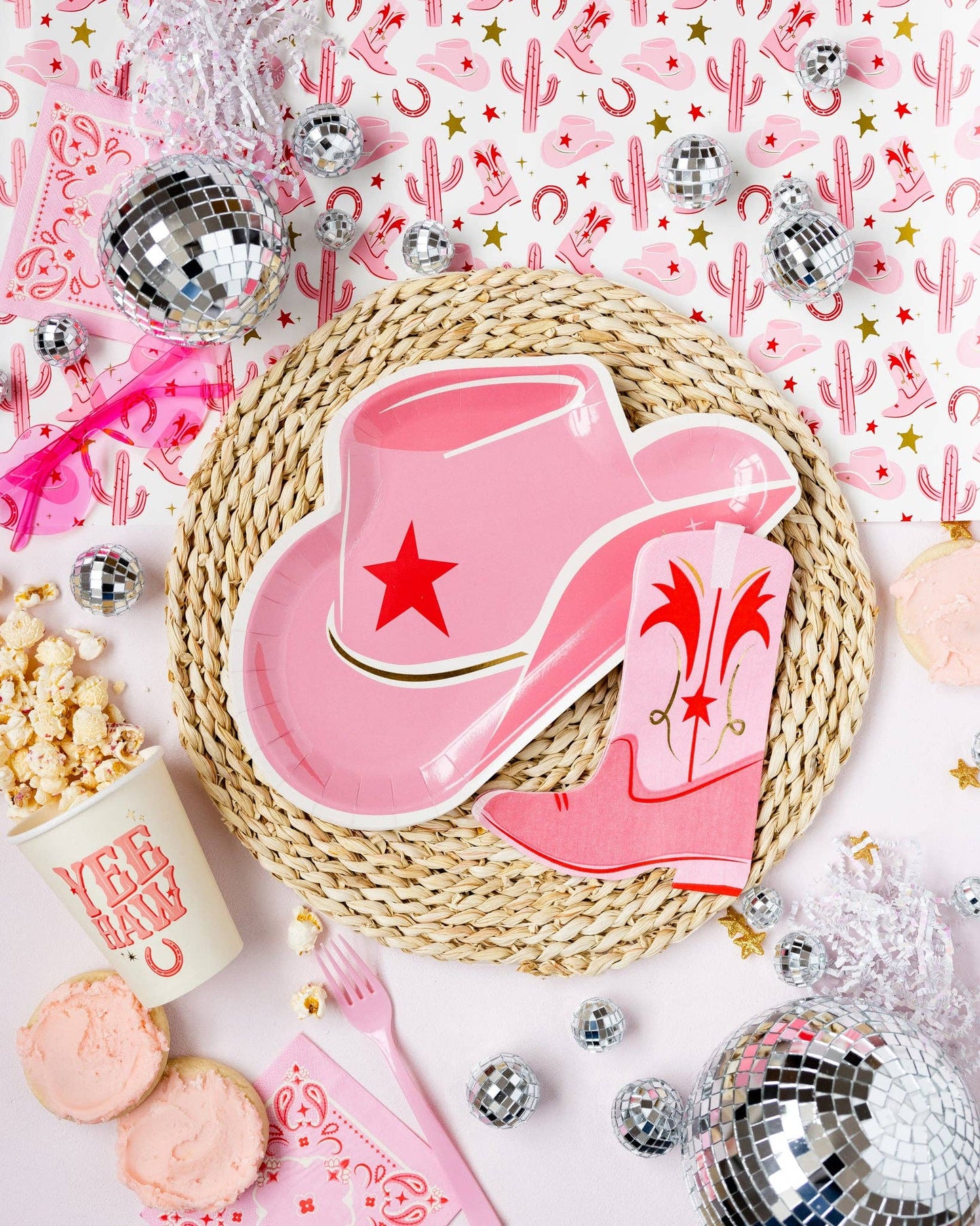 Pink cowboy hat and boot napkin on a woven placemat with festive western decorations.