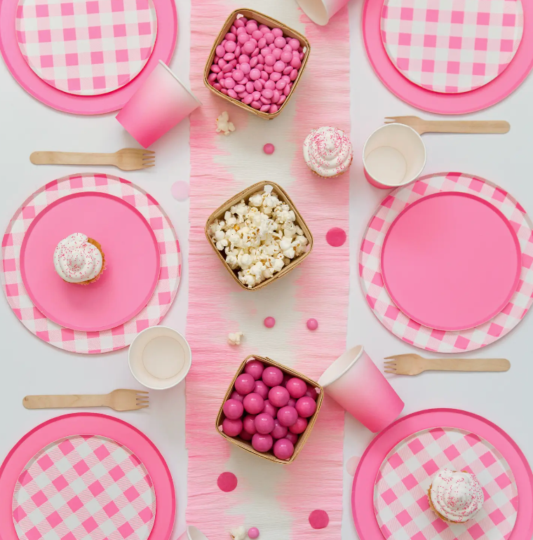 Laydown of a table with pink plates, cups and table runner