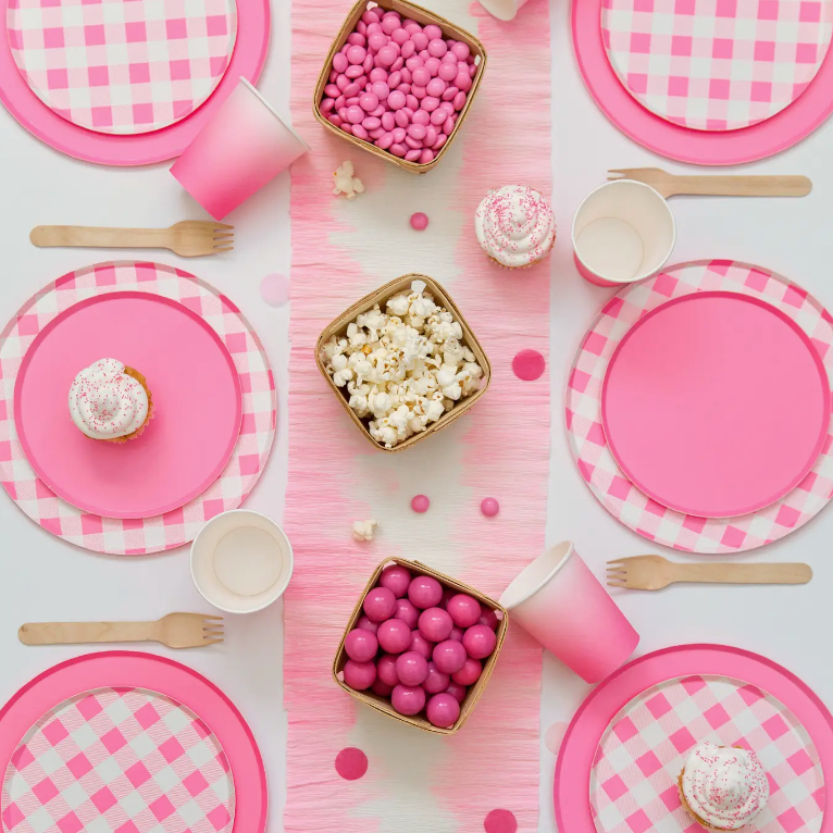 Laydown of a table with pink plates, cups and table runner
