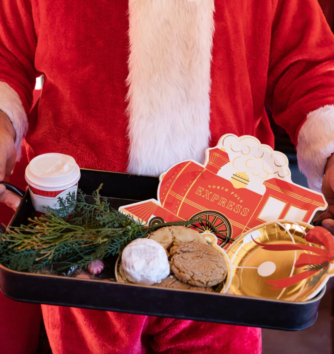 Image of Santa holding a tray of cookies and festive paper plates