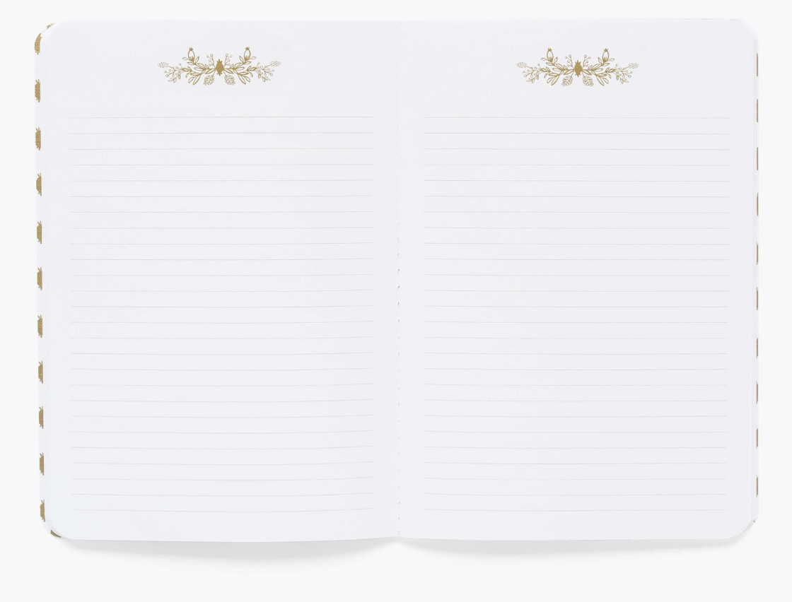 Inside look of notebook with lined pages and gold accents