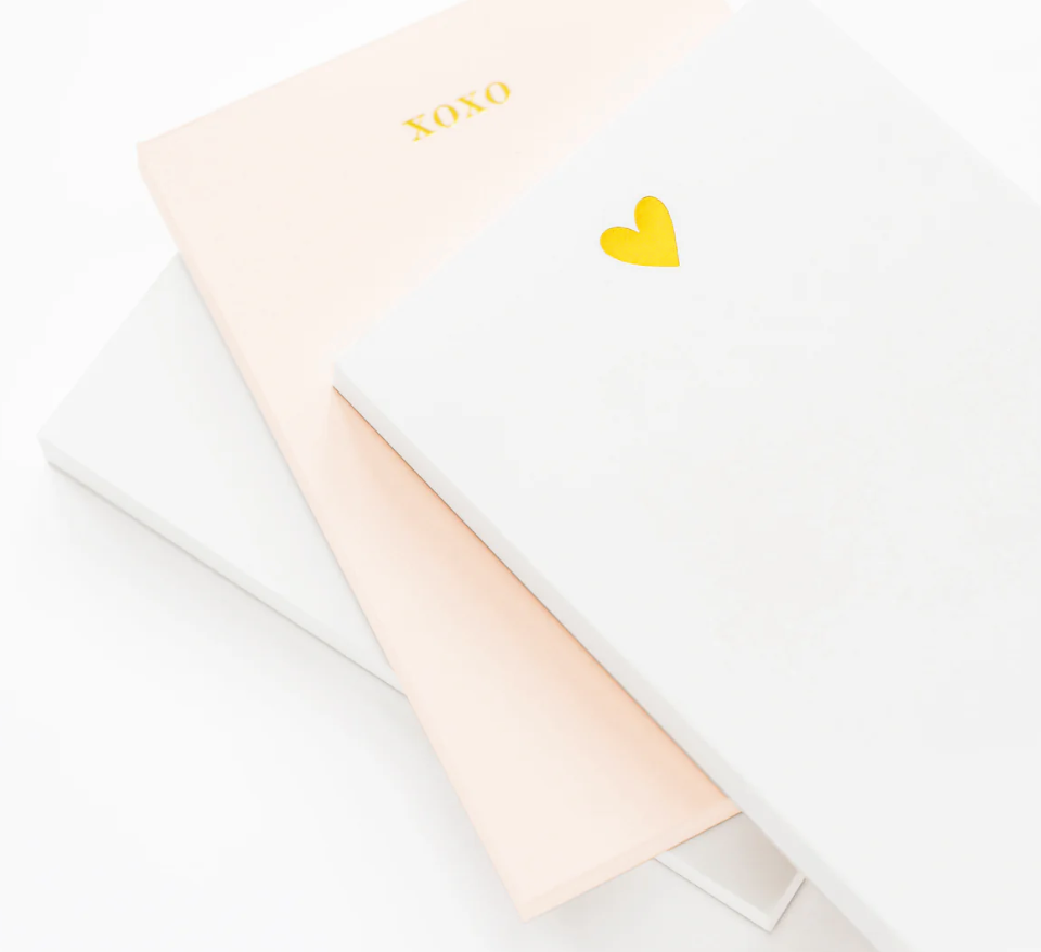 Stack of notebooks including one with a gold heart and one with 'xoxo' detail