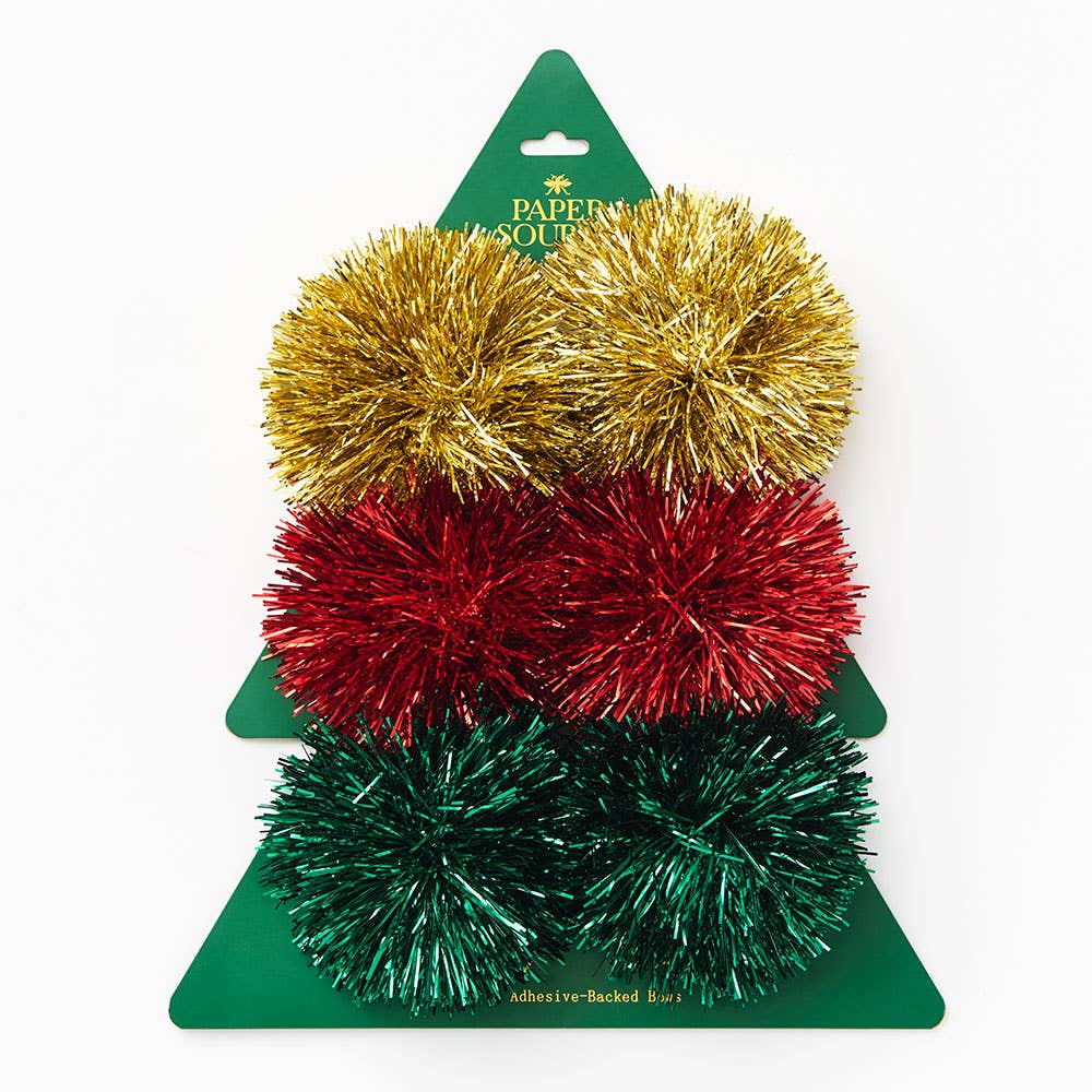 Set of gold, red and green tinsel pom-poms on green backing with Paper Source branding.