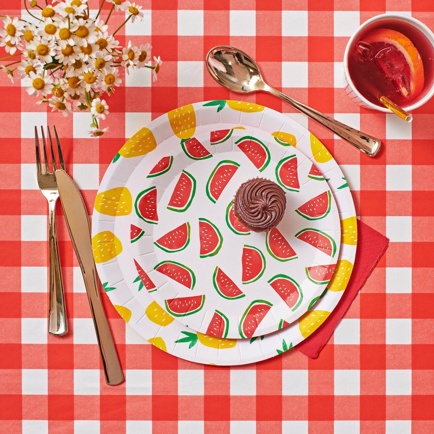 Colorful paper plate with watermelon pattern on a red checkered tablecloth.