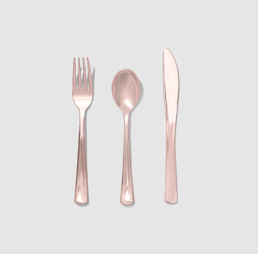 Rose gold fork, spoon, and knife set on a light gray background