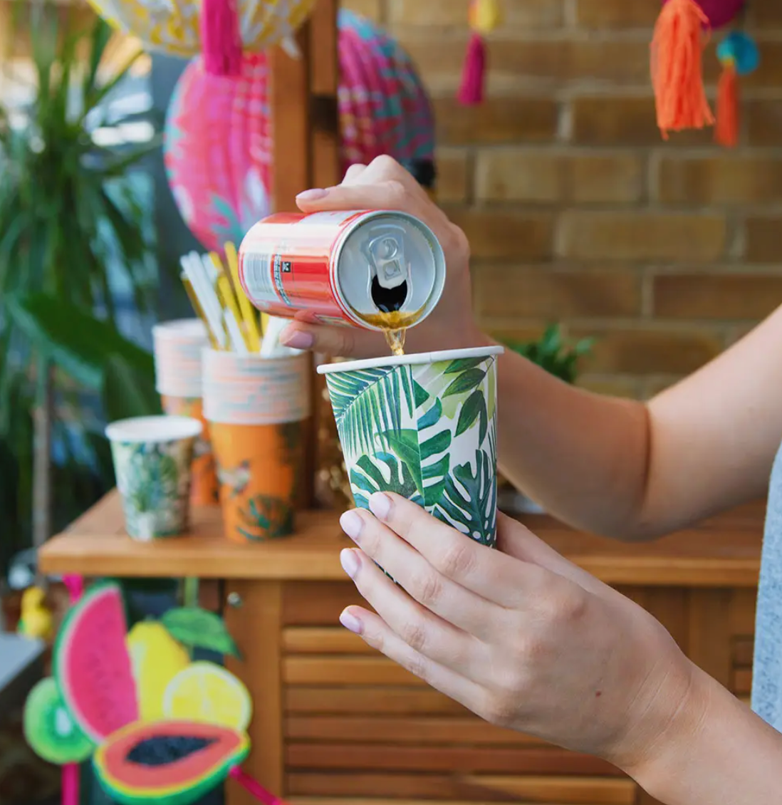 Image of someone pouring a drink into the green leaf paper cup