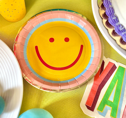 Colorful paper plate with smiley face design on a yellow surface