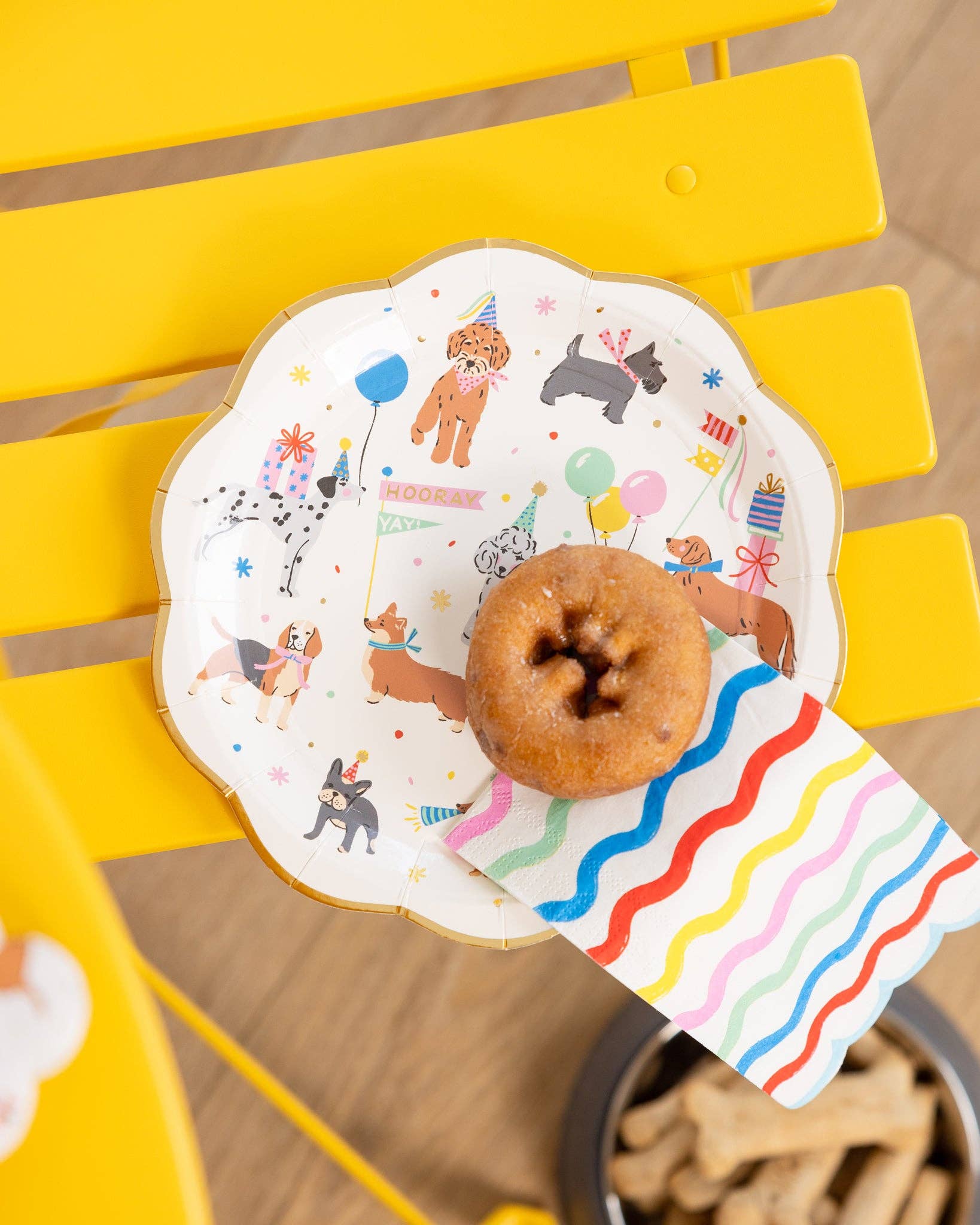 Donut and napkin on a colorful plate depicting dog illustrations