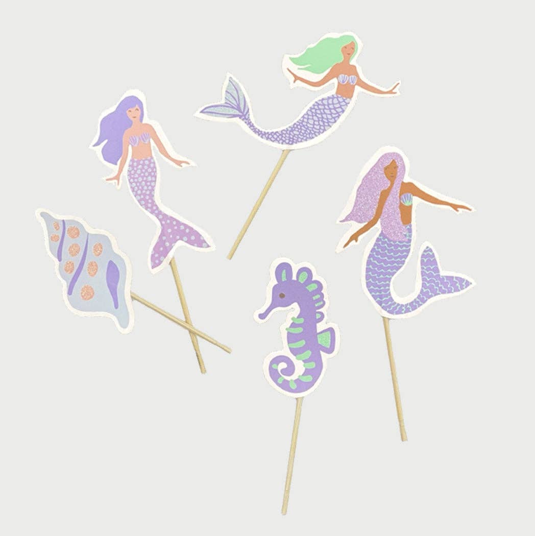 Mermaid and seahorse cupcake toppers on sticks against a light gray background