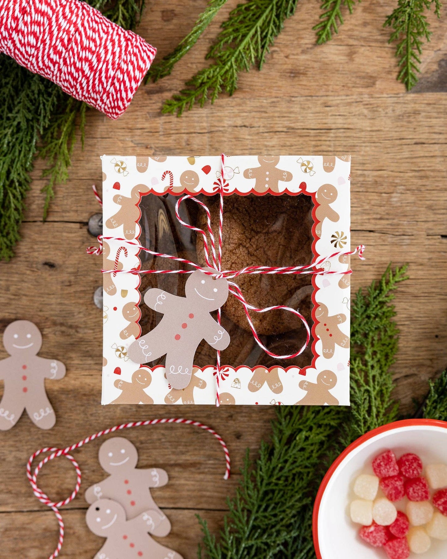 Gingerbread cookie box on a wooden table with red/white twine