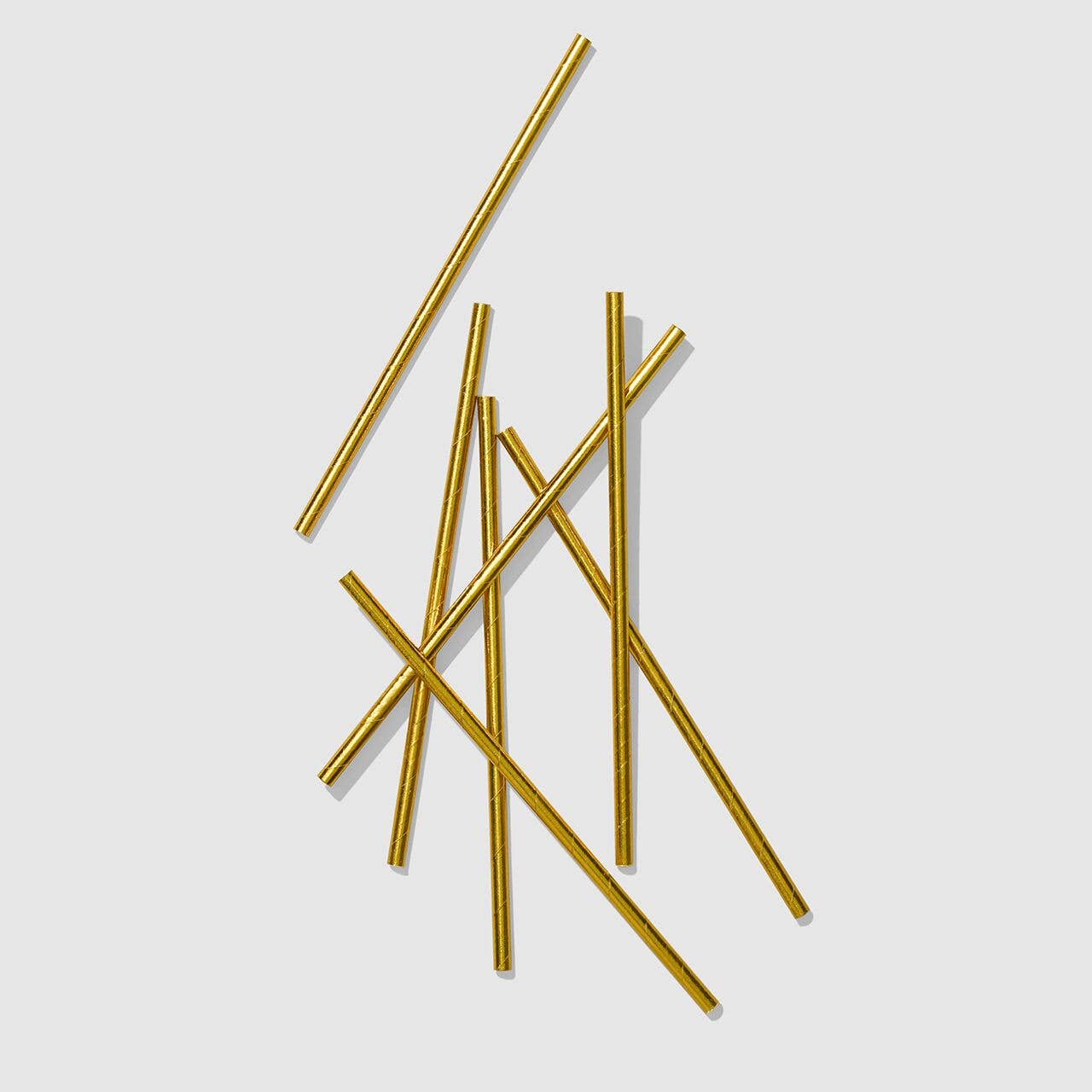 Gold straws on a light gray background