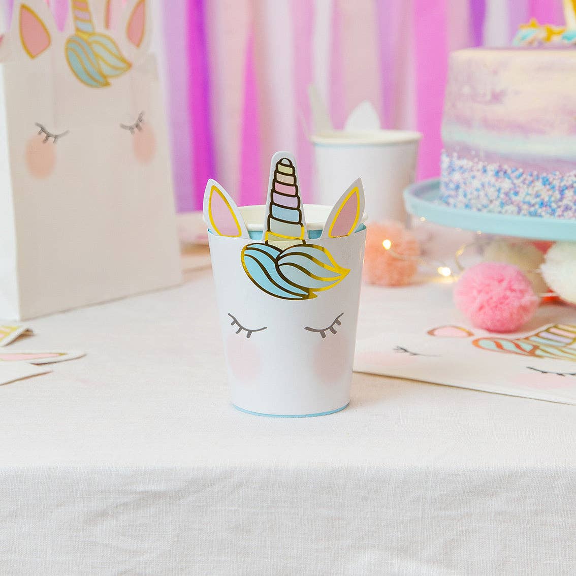 Unicorn paper cup on a table with a colorful background