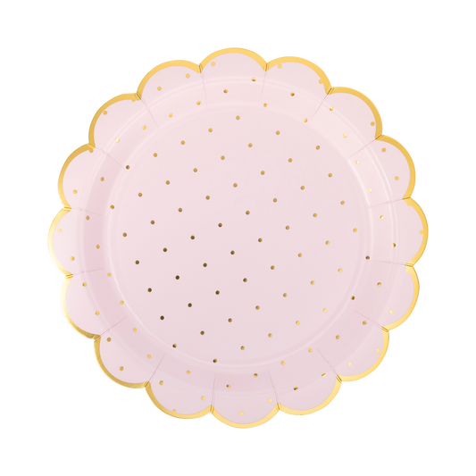 Round pink plate with gold polka dots and a scalloped edge on a white background