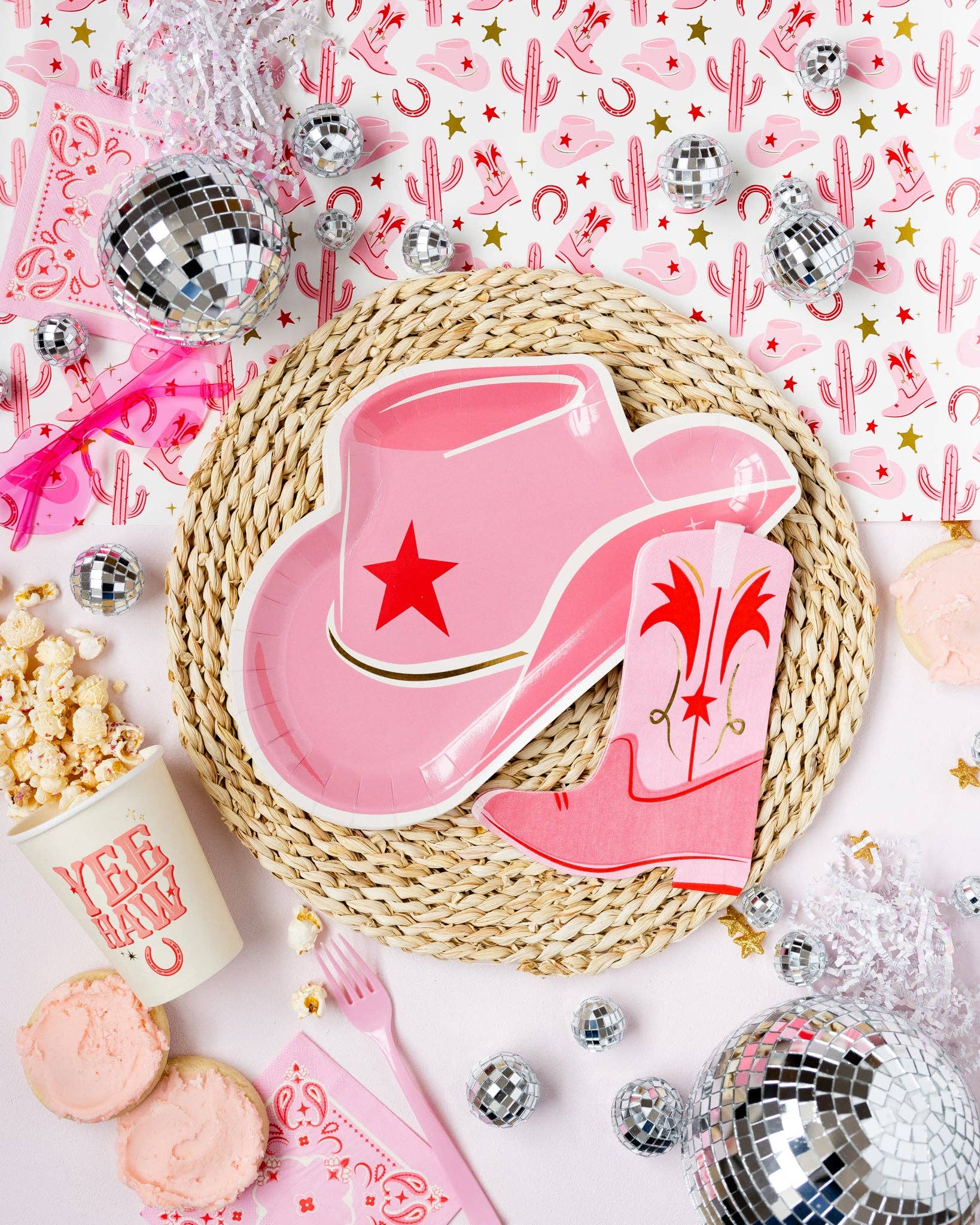 Pink cowboy hat and boot napkin on a woven placemat with festive western decorations.