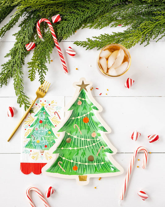 Bird's eye view of a decorative Christmas laydown featuring tree-shaped plates, candy canes and pine branches.