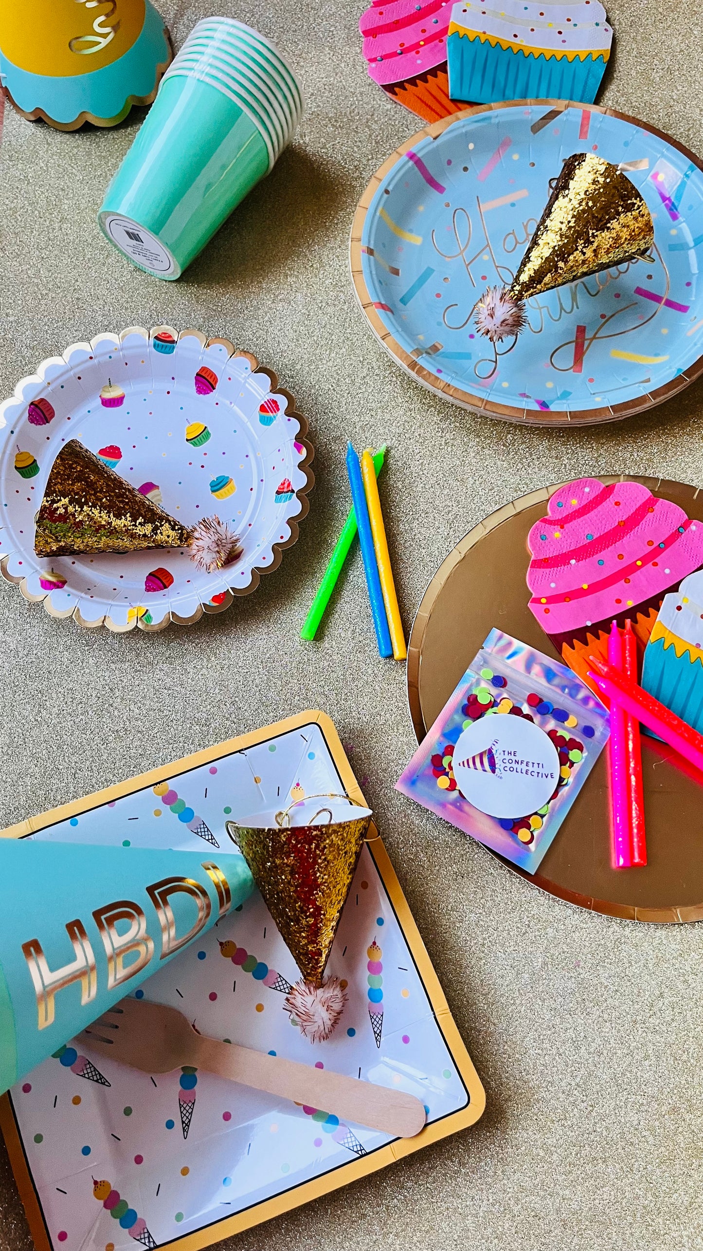 Bird's eye view of birthday party decor laydown on a gold glitter background