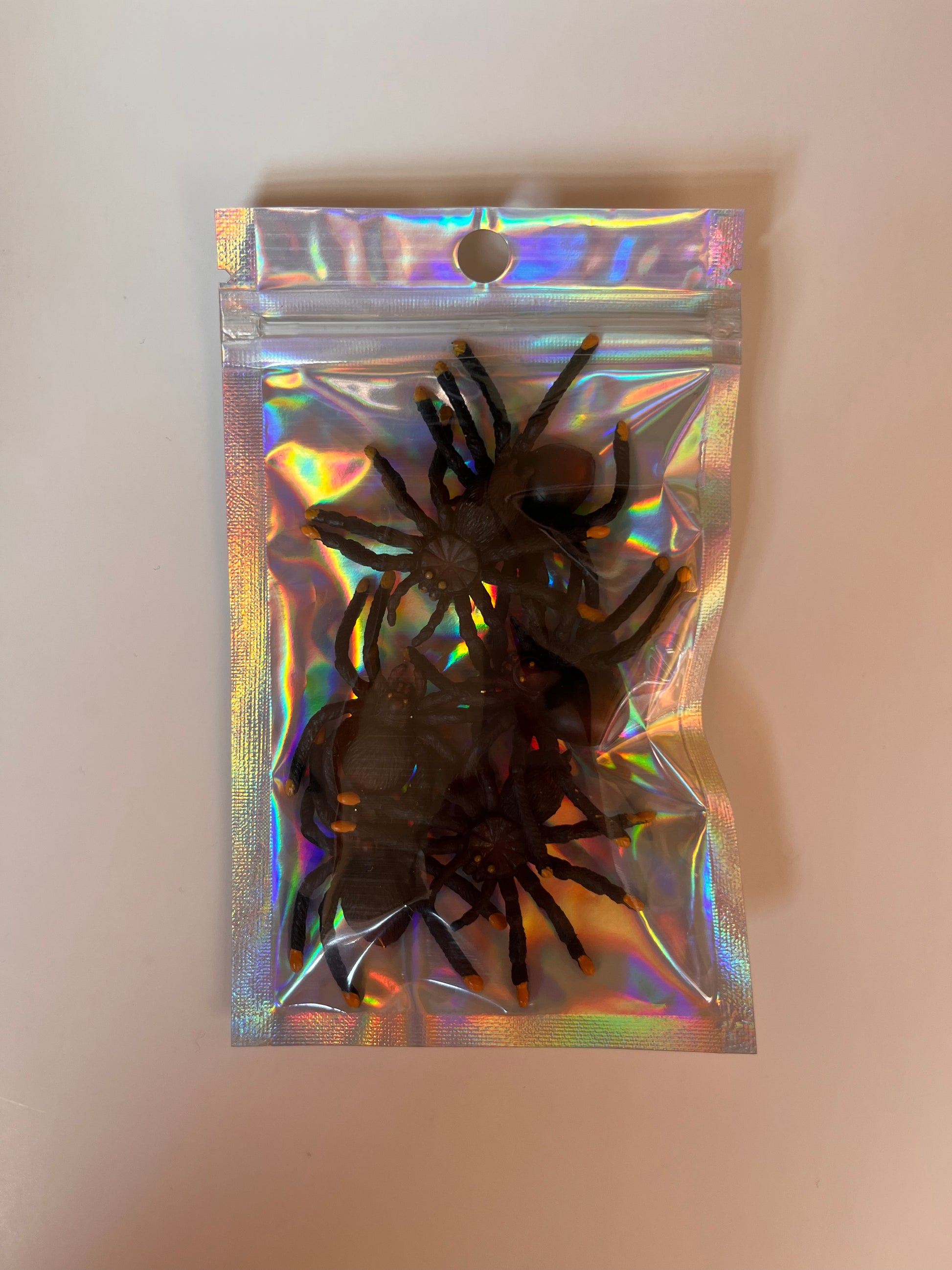 Image of black plastic spiders in holographic packaging