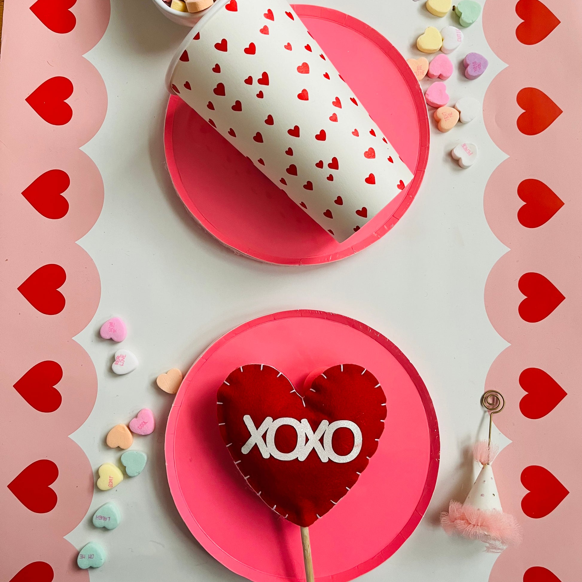 Valentine's Day table setting featuring heart print to-go coffee cup and felt heart picks