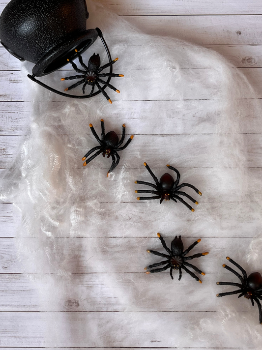 Black plastic spiders on top of white cobwebs