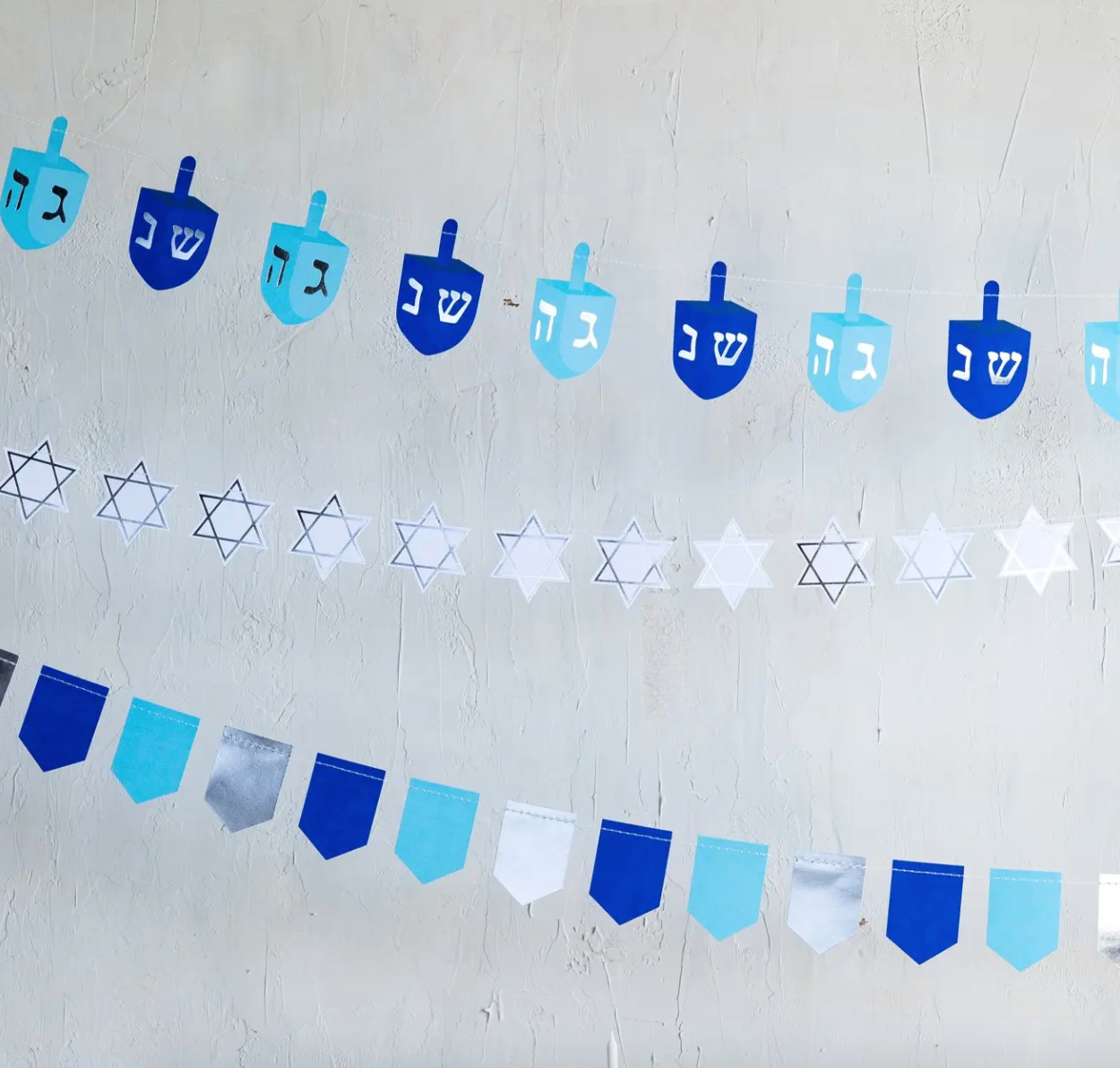 Hannukah banner featuring rows of dreidels, stars and pennants