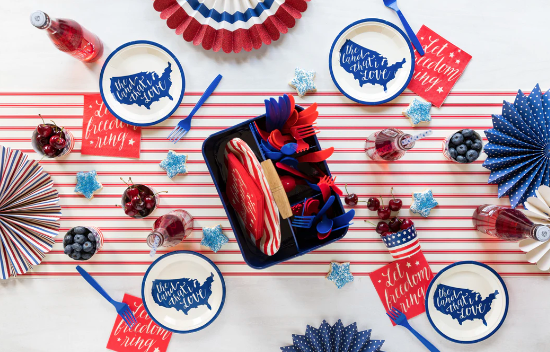 4th of July table setting featuring a red and white striped table runner