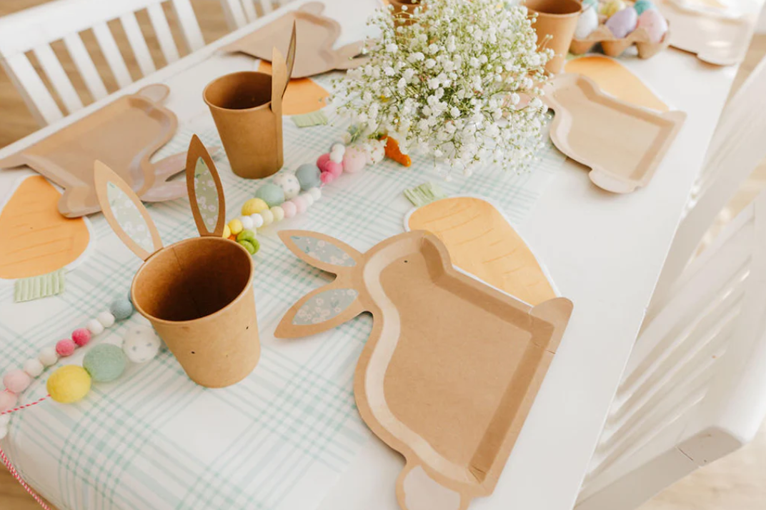 Front image of a carrot-shaped paper napkin on a decorative Easter table.