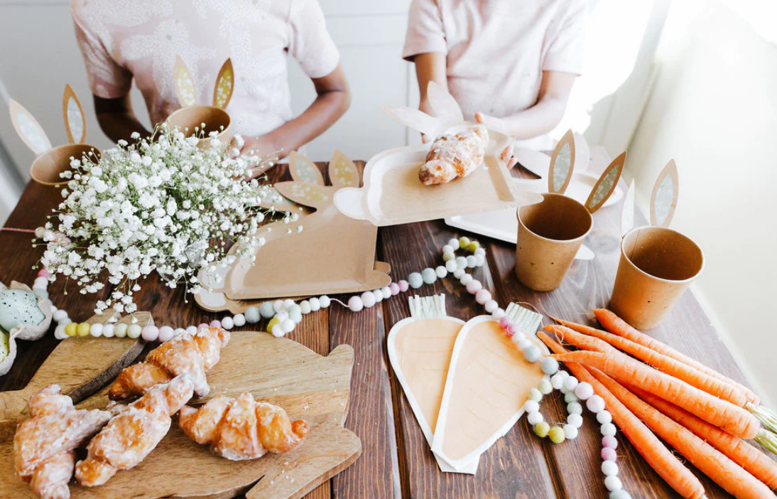 Front image of a carrot-shaped paper napkin on a decorative Easter table.