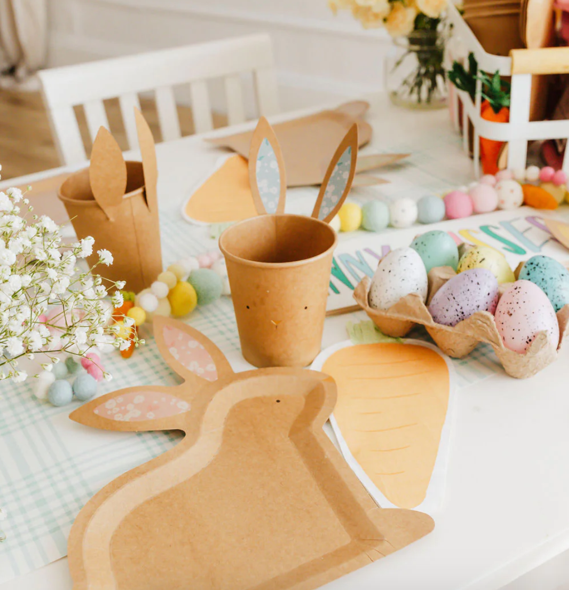 Front image of a carrot-shaped paper napkin on a decorative Easter table.