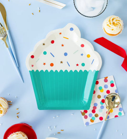 Cupcake-shaped party plate with colorful sprinkles and party supplies on a blue background