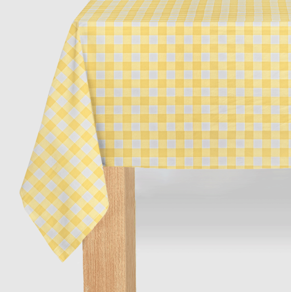Yellow and white checkered tablecloth on a wooden table with a light gray background