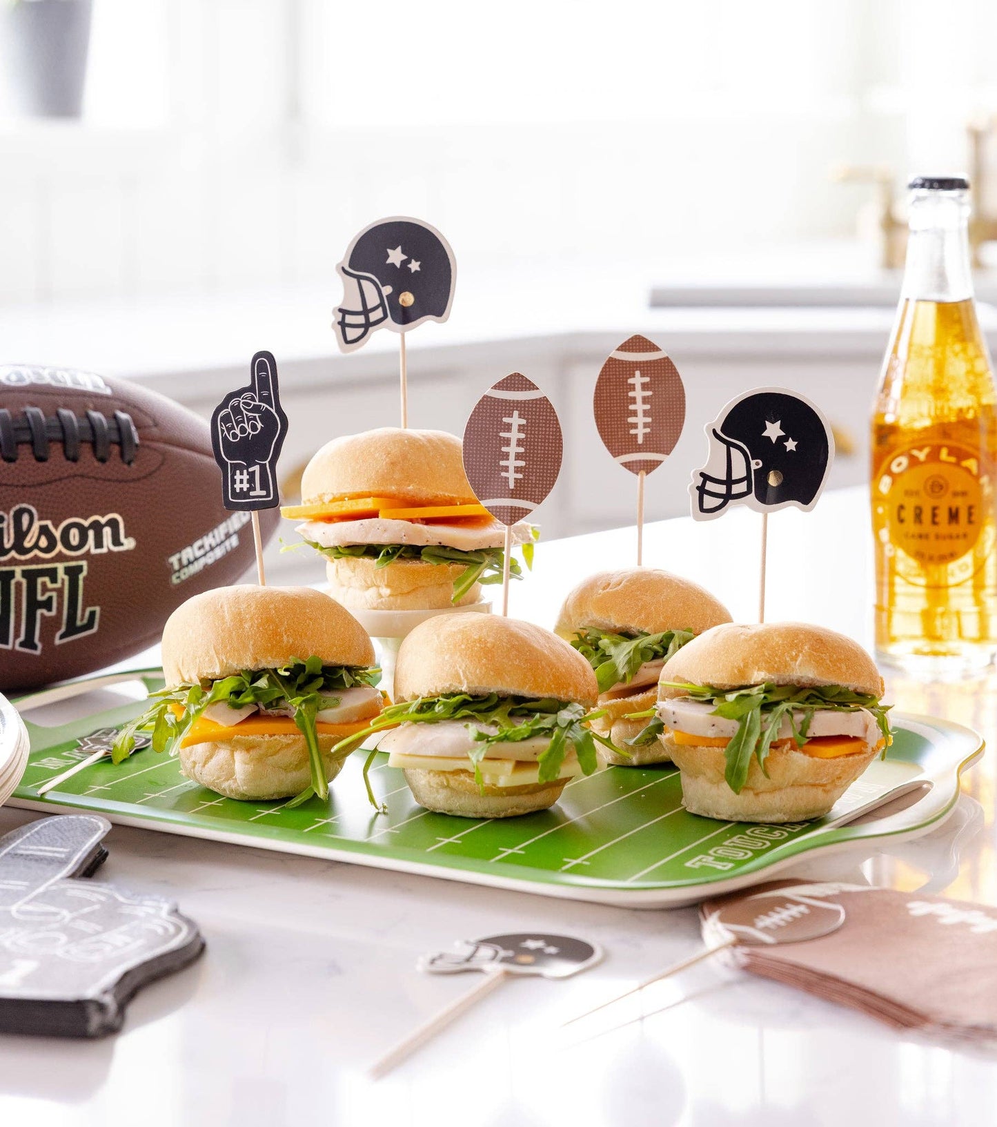 Mini burgers on a platter with football food picks.