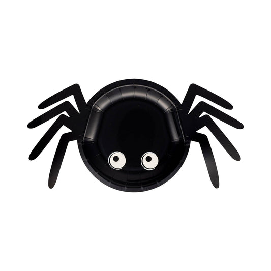 Black spider-shaped plate with googly eyes on a white background