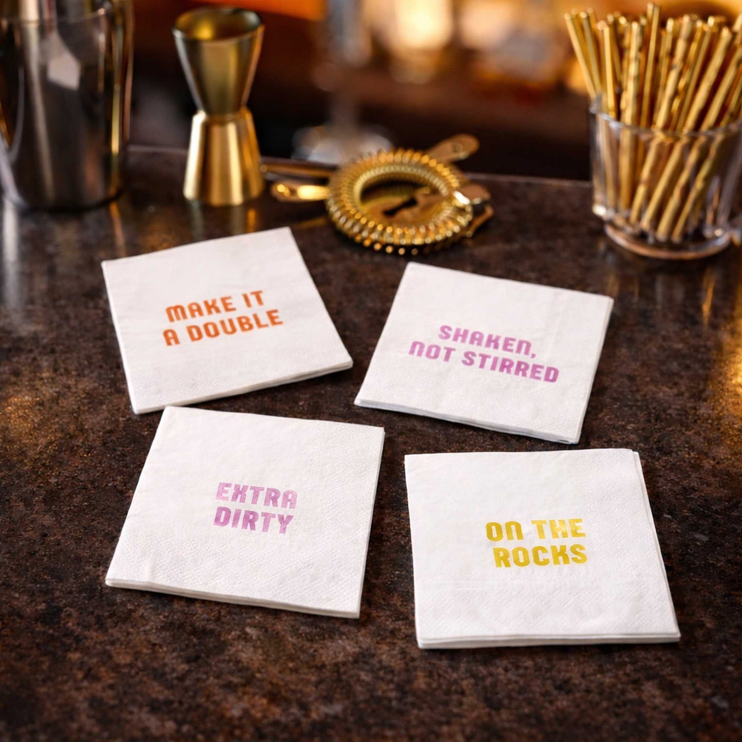 Cocktail-themed napkins with punny text on a marble bar counter