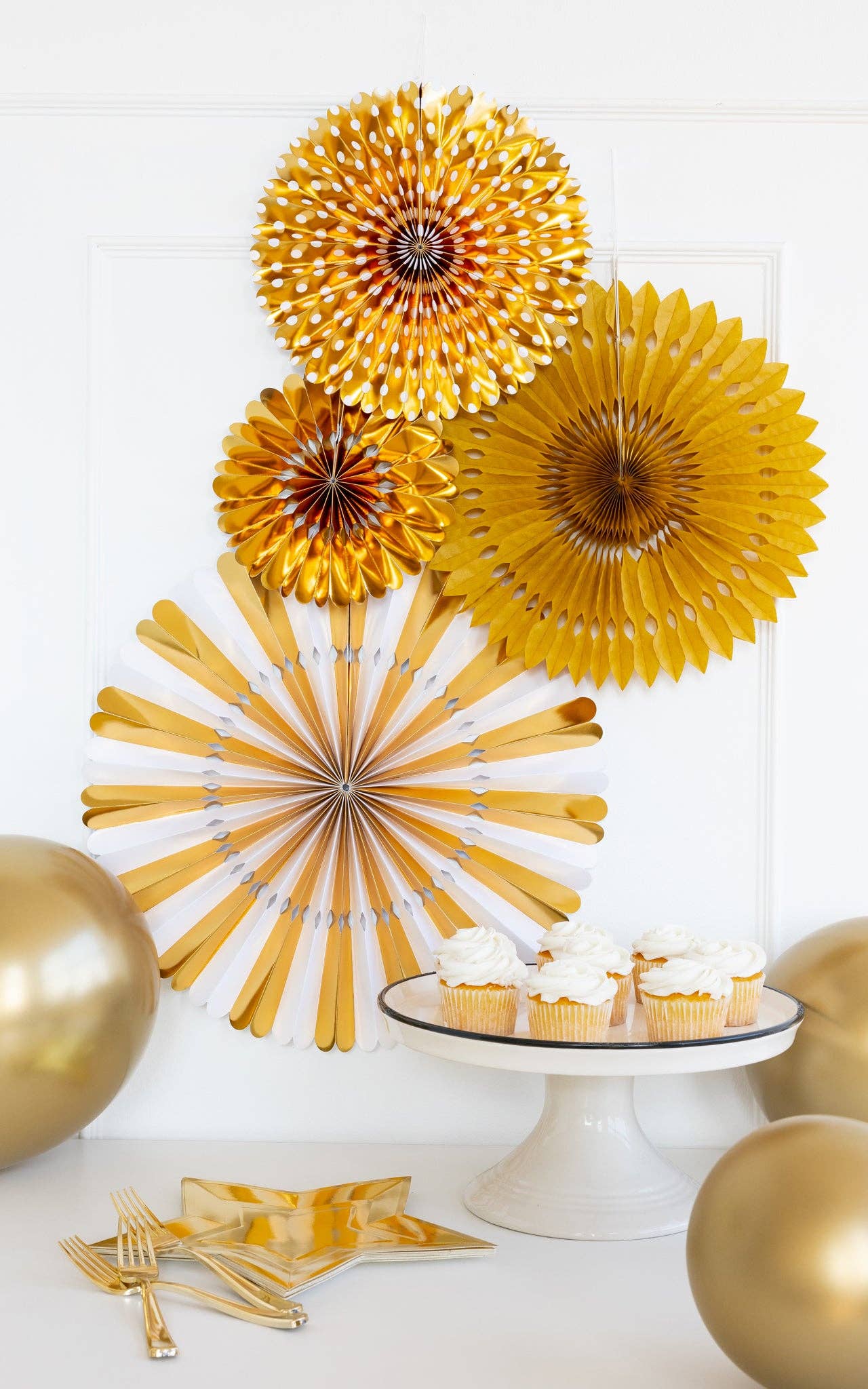 Party scene with gold paper fans and gold star-shaped plates