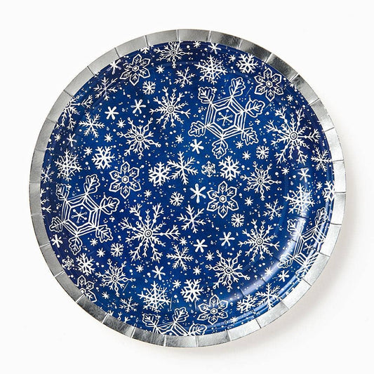 Round paper plate with white snowflake pattern on a blue background