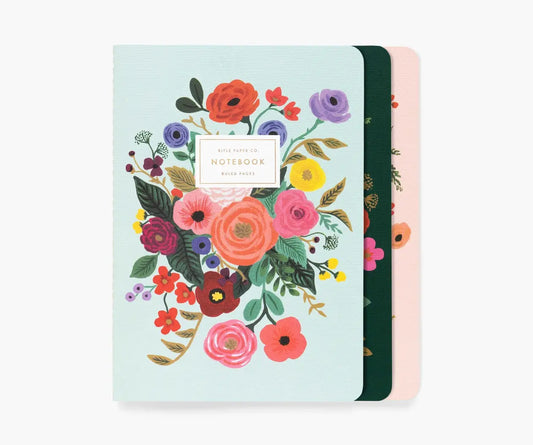 Set of three notebooks with floral designs on a white background