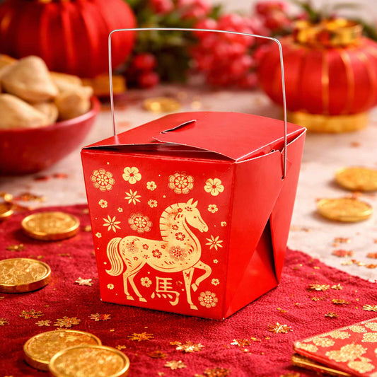 Red to go food box with gold horse design on a festive table with red lanterns and cookies.