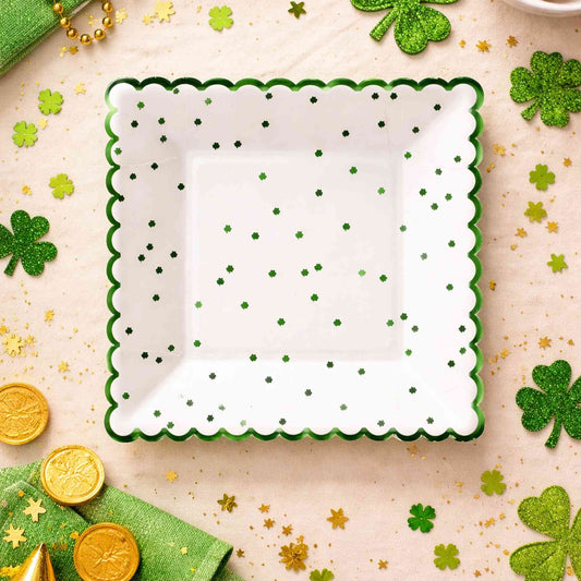 Decorative plate with green shamrocks on a festive background with gold coins and green napkins.