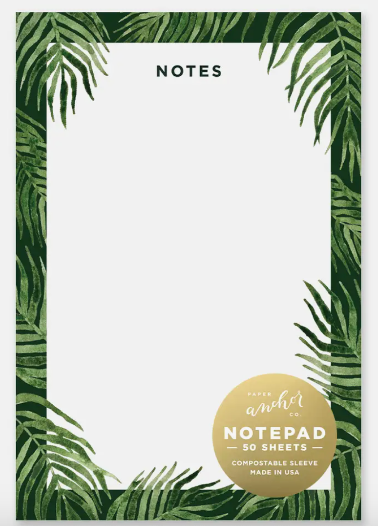 Image of a notepad decorated with palm fronds with a compostable sticker on the front